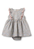 Blumenkleid mit gekräuselten Schulterakzenten, hellblauen und rosa Mustern auf grauem Hintergrund und einem Höschenboden mit Druckknopfverschluss.