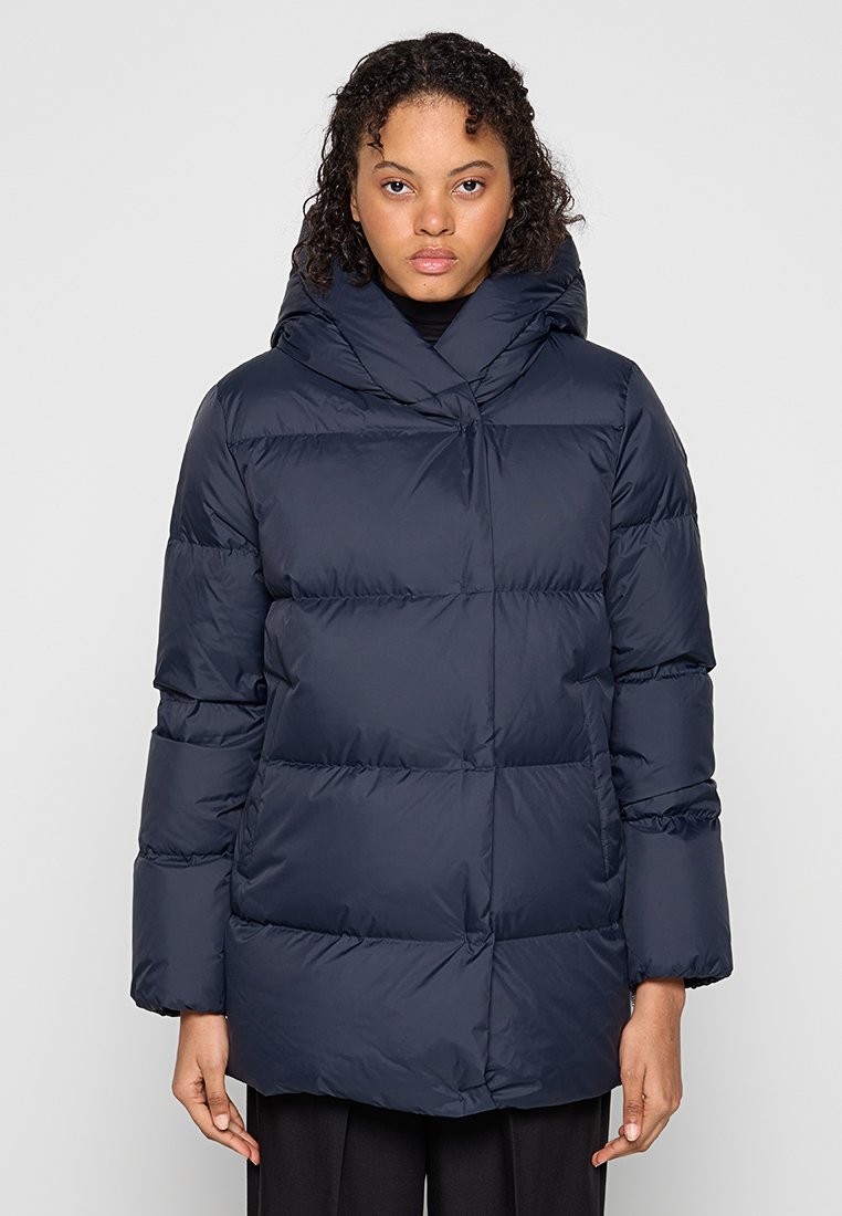 Dunkelblaues Daunenjacke mit Kapuze, ausgestattet mit einem geometrischen Steppdesign, übergroßen Ärmeln und einem leicht längeren Schnitt für zusätzliche Wärme.