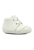 Weißes Baby-Kinderschuh aus Leder mit abgerundeter Spitze, Schnürung vorne, sichtbaren Nähten und flexiblem Gummisohlen für die ersten Schritte.