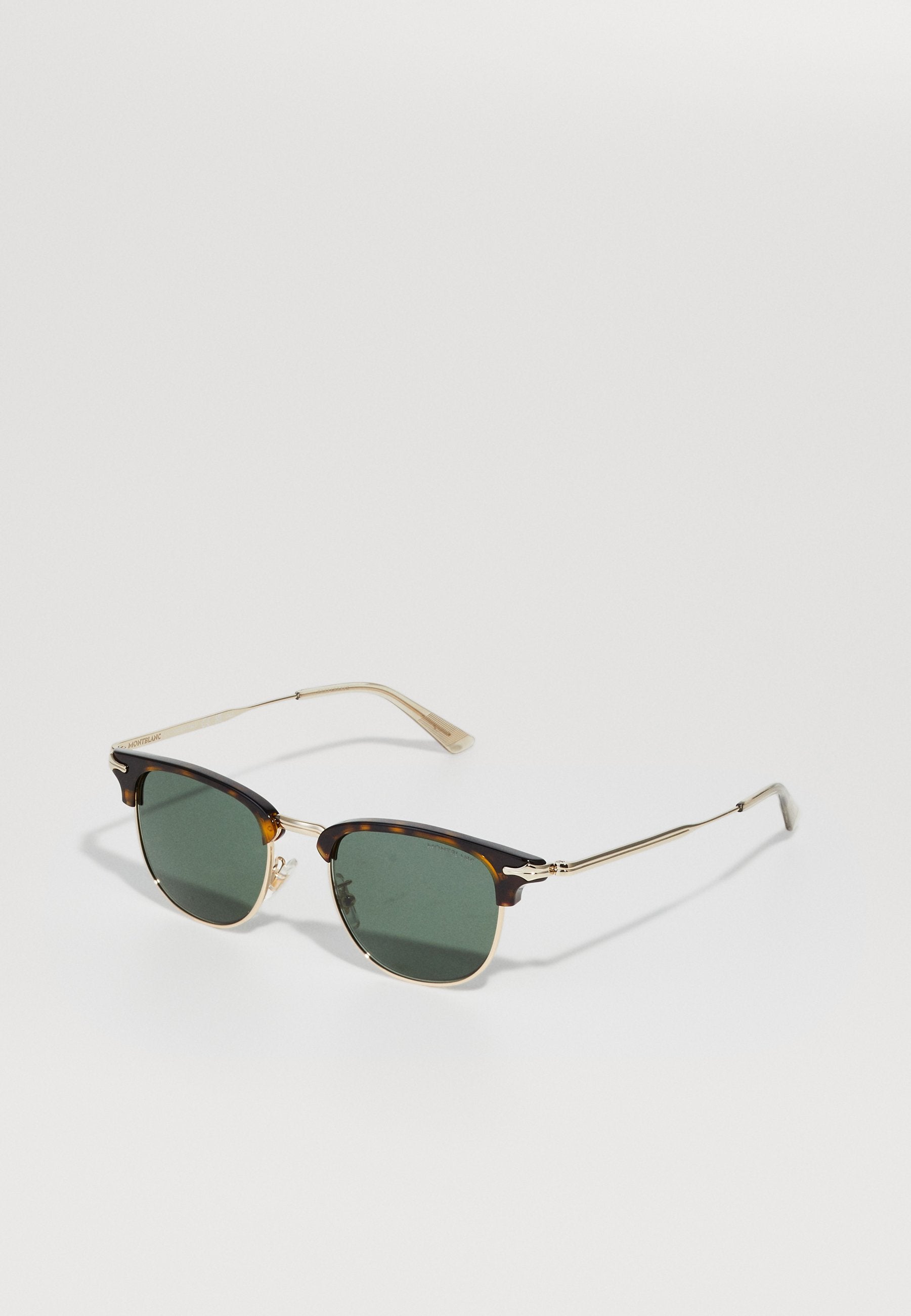 Schildpatt-Sonnenbrille mit grünen Gläsern. Das Gestell besitzt goldene Akzente, eine Metallbrücke und schmale Bügel. Klassische quadratische Form.