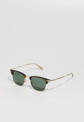 Schildpatt-Sonnenbrille mit grünen Gläsern. Das Gestell besitzt goldene Akzente, eine Metallbrücke und schmale Bügel. Klassische quadratische Form.