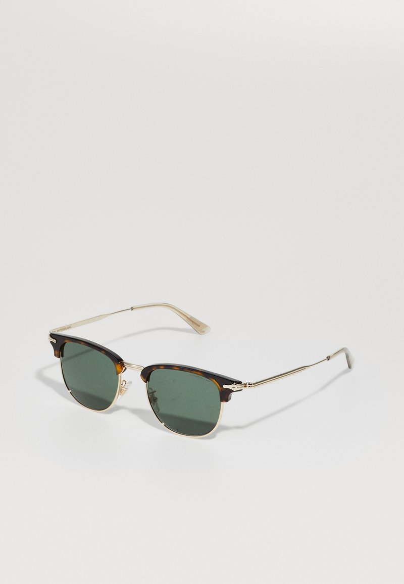 Schildpatt-Sonnenbrille mit grünen Gläsern. Das Gestell besitzt goldene Akzente, eine Metallbrücke und schmale Bügel. Klassische quadratische Form.