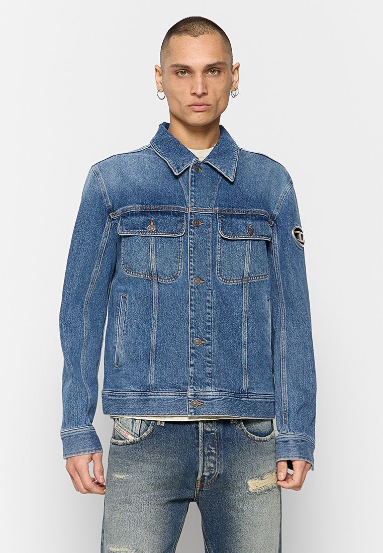 Blaue Jeansjacke mit klassischem Kragen, zwei Brusttaschen und Knöpfen. Verfügt über kontrastierende Nähte und ein Logo-Patch am Ärmel.