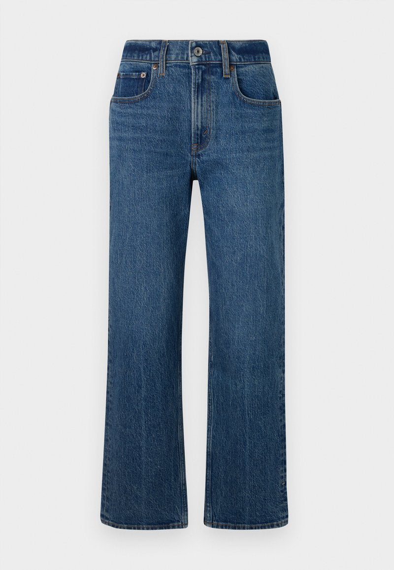 Blaue Denim-High-Waist-Jeans in weitem Schnitt, präsentiert vor einem schlichten weißen Hintergrund, mit vorderen Taschen, einem Knopfverschluss und einem leicht ausgewaschenen Finish.