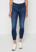 Schmale dunkelblaue Denim-Jeans mit mittelhohem Bund, ausgestattet mit fünf Taschen und kontrastierenden orangefarbenen Nähten. Kombiniert mit weißen Sneakern.