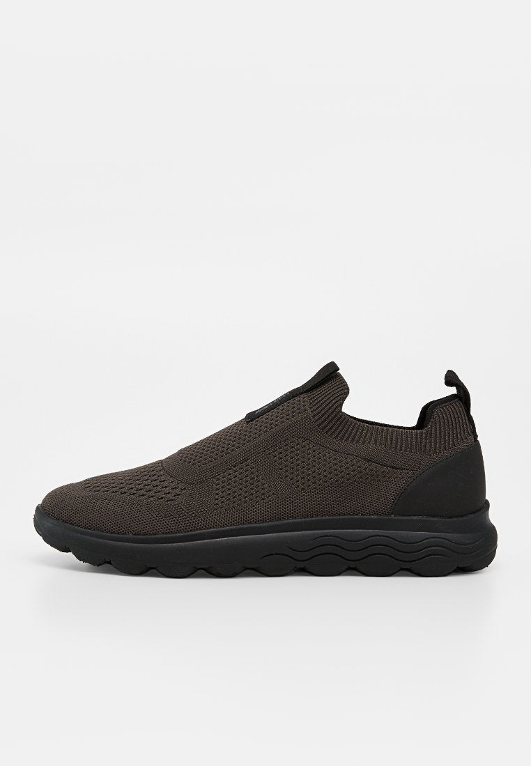 Schwarzer Slip-On-Sneaker mit atmungsaktivem Strick-Obermaterial, elastischem Kragen, Zuglasche an der Ferse und strukturierter Gummisohle mit Wellenmuster.