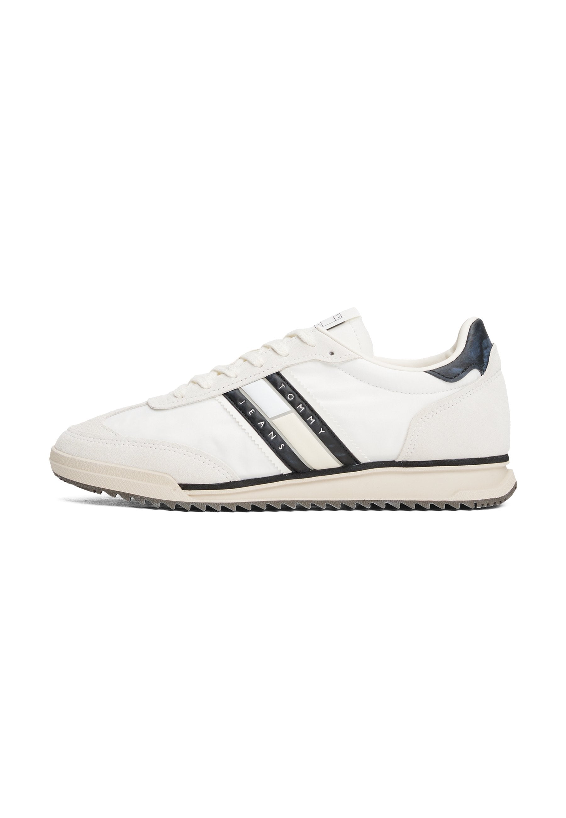 Weißer Sportschuh mit schwarzen und cremefarbenen Streifen, Obermaterial aus glattem Leder, Gummisohle und strukturiertem Fersenakzent. Schnürsenkel und Logo an der Seite.
