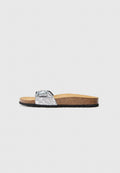 Flip-Flop mit Korksohle, schwarzer Gummisohle und einem einzelnen silbernen Glitzerriemen mit verstellbarem Schnallenverschluss.
