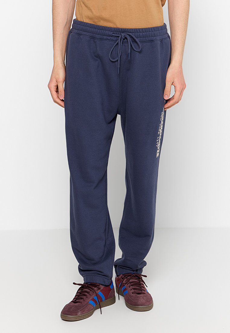 Navyblaue Jogginghose aus weichem Stoff, mit einem elastischen Taillenbund und Zugband. Seitliches Logodetail in Weiß bedruckt.