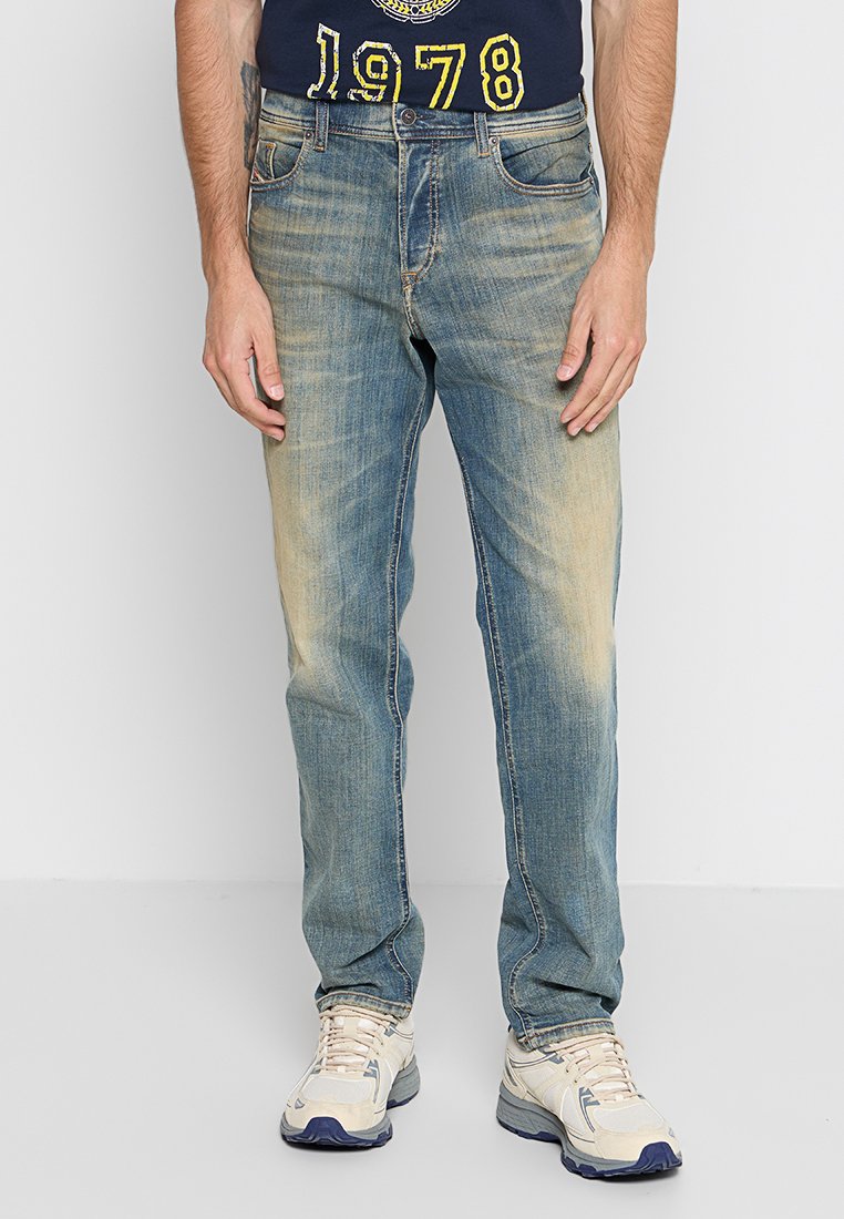 Hellblaue Denim-Jeans mit einem ausgewaschenen Finish, klassischem Fünf-Taschen-Design und geradem Schnitt. Tragen mit hellen Sneakers.