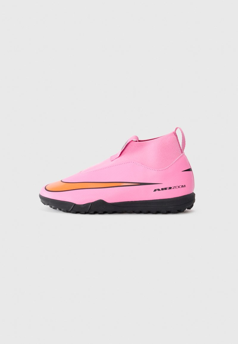 Rosa synthetische Fußballschuhe mit einem orangefarbenen Akzentstreifen, verfügen über ein Slip-On-Design und eine schwarze Gummisohle mit strukturiertem Grip.