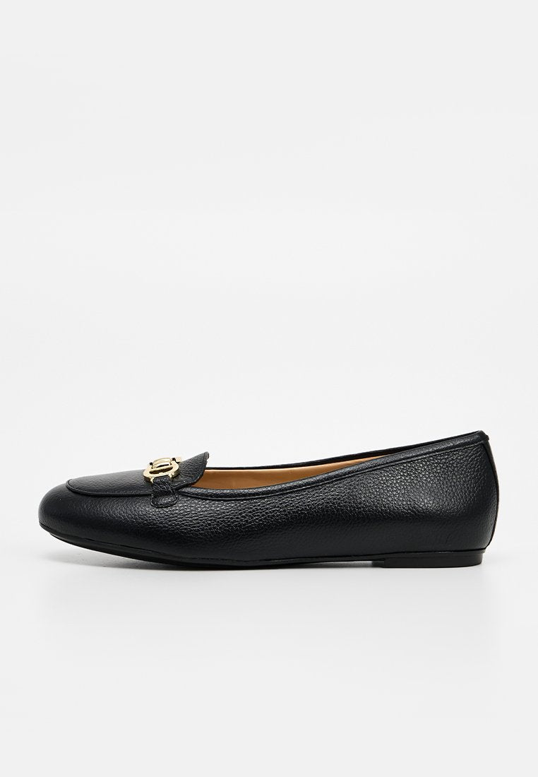 Schwarzer Leder-Flacher Slipper mit goldener dekorativer Schnalle oben, abgerundeter Spitze und niedrigem Absatz, entworfen für Damen zur Freizeit- oder formellen Kleidung.