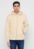Beige Kapuzenpulli mit Reißverschluss aus weichem Stoff mit einem weißen Innenfutter, Kapuze mit Kordelzug, Fronttaschen und dezentem Logo auf der Brust.