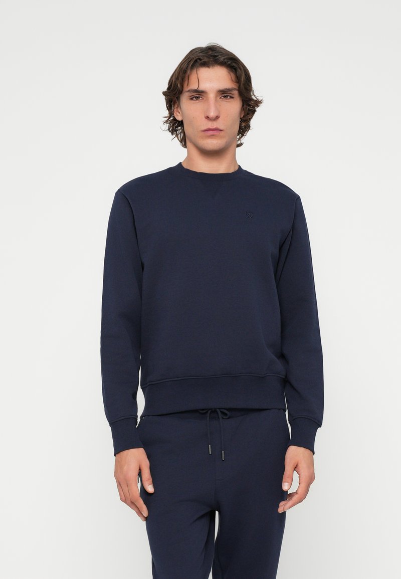 Marineblaue Sweatshirt aus Fleece-Material, mit Rundhalsausschnitt, gerippten Bündchen und einem dezenten Logo auf der Brust. Glatte Textur.