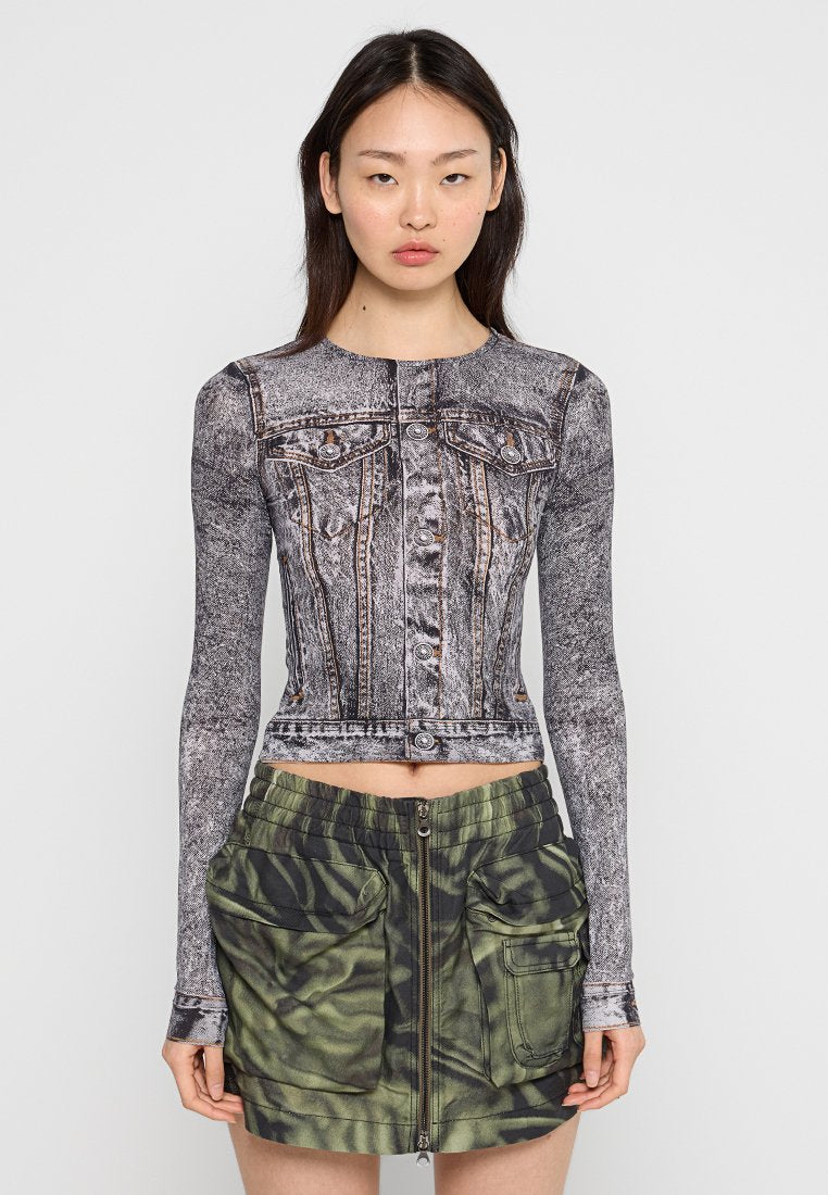 Langärmliges, geschnittenes Oberteil mit Denim-Print, knöpfbare Vorderseite und Brusttaschen; kombiniert mit einem grün-beigen Camouflage-Rock mit Reißverschluss und großen Taschen.