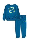 Blauer Baumwoll-Sweatshirt mit gerippten Bündchen, versehen mit einem neon-gelben Nike-Logo in einem Quadrat. Passende blaue Sweatpants mit Logo an der Beinöffnung.