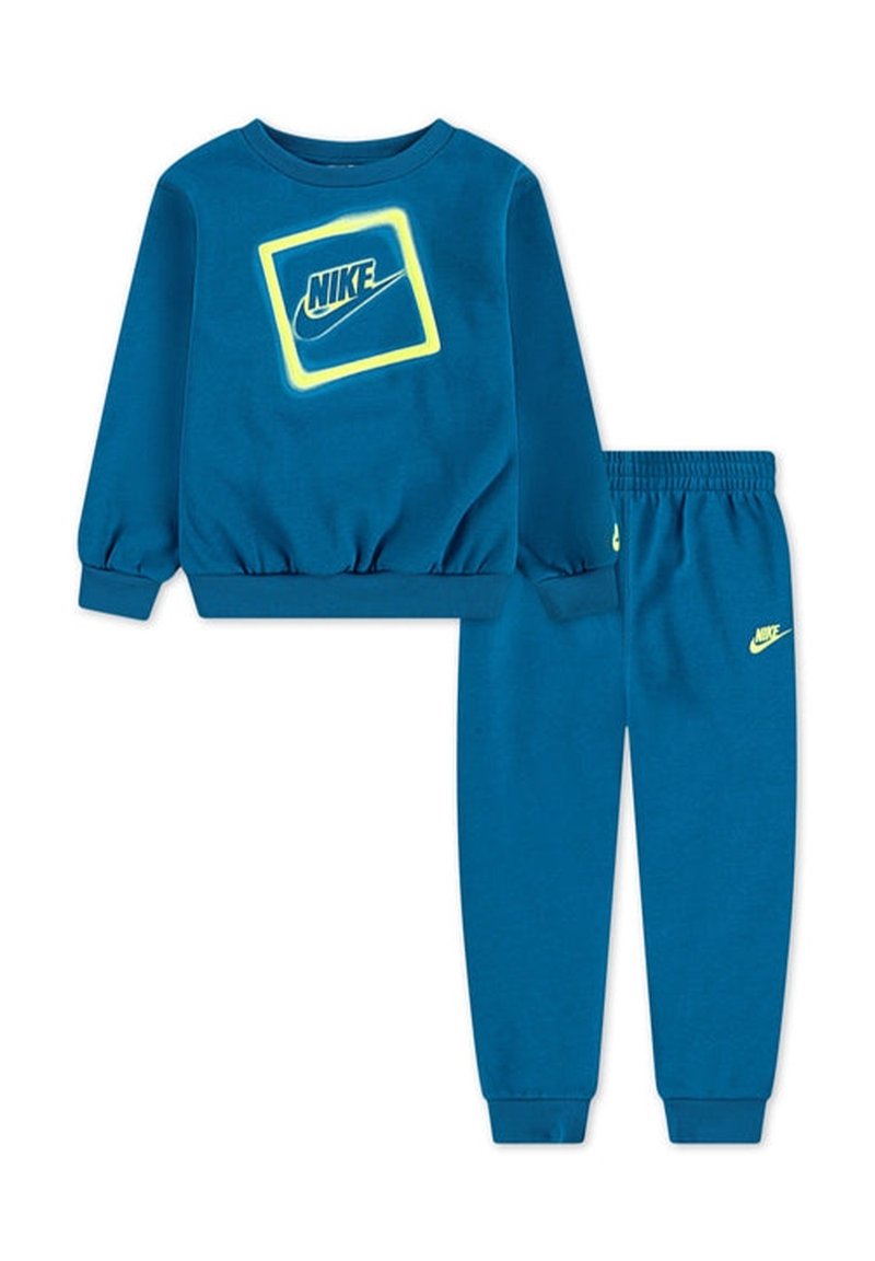 Blauer Baumwoll-Sweatshirt mit gerippten Bündchen, versehen mit einem neon-gelben Nike-Logo in einem Quadrat. Passende blaue Sweatpants mit Logo an der Beinöffnung.