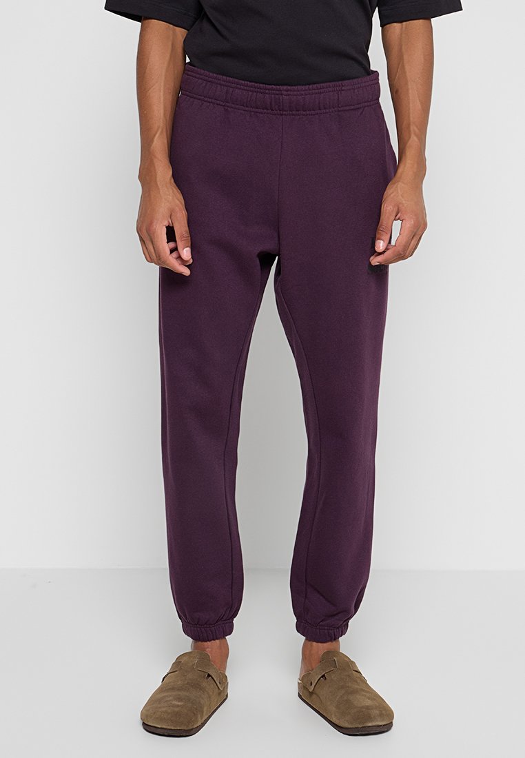Lila Jogginghosen mit elastischem Bund und Bündchen an den Knöcheln. Hergestellt aus weichem Material, mit lockerem Schnitt und minimalistischem Design.