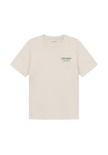 Baumwoll-T-Shirt in hellem Beige, mit kurzen Ärmeln und Rundhalsausschnitt. Auffälliger grüner Textdruck auf der linken Brustseite.