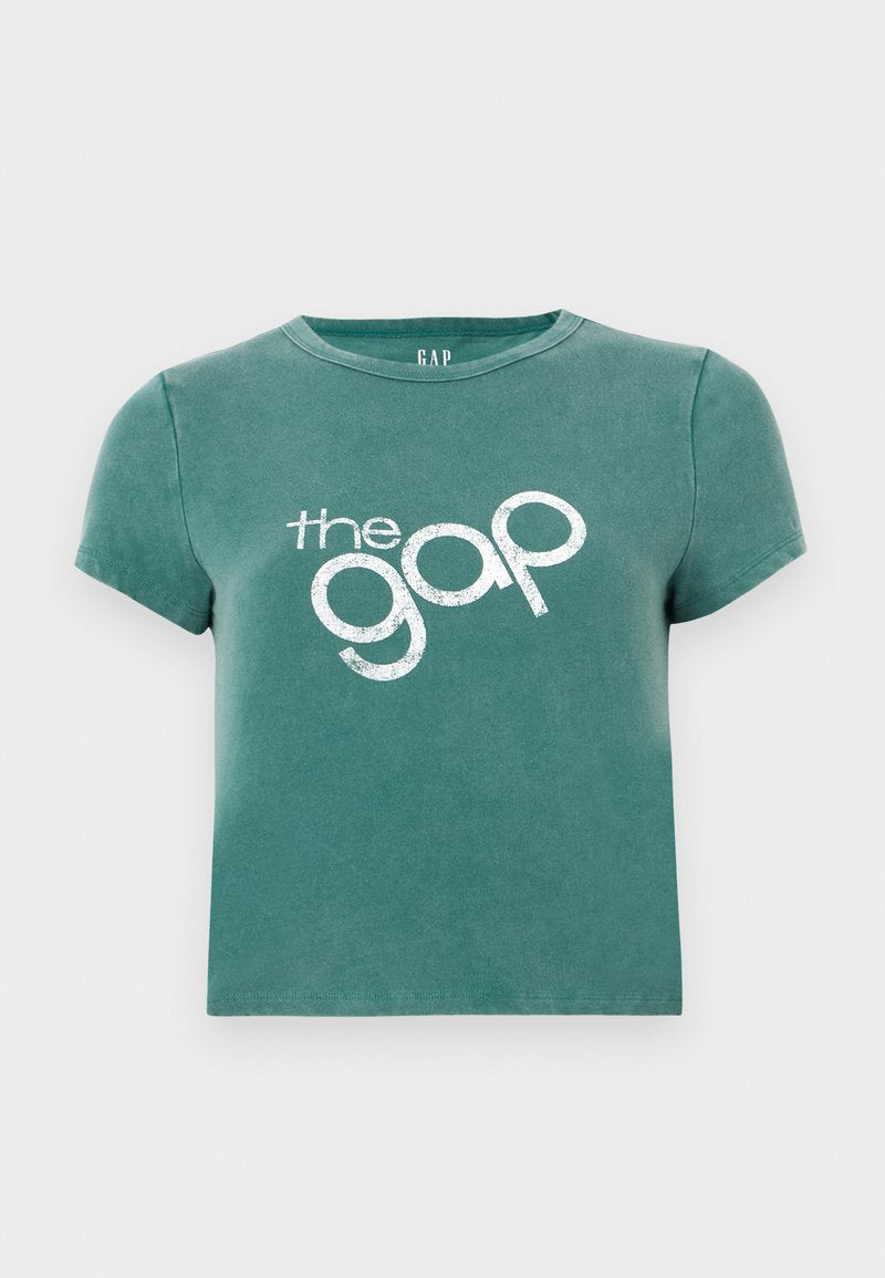 Grünes T-Shirt mit kurzen Ärmeln aus Baumwolle, vorne mit dem weißen Aufdruck "the gap". Gekürztes Design mit rundem Halsausschnitt.
