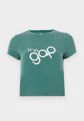 Grünes T-Shirt mit kurzen Ärmeln aus Baumwolle, vorne mit dem weißen Aufdruck "the gap". Gekürztes Design mit rundem Halsausschnitt.