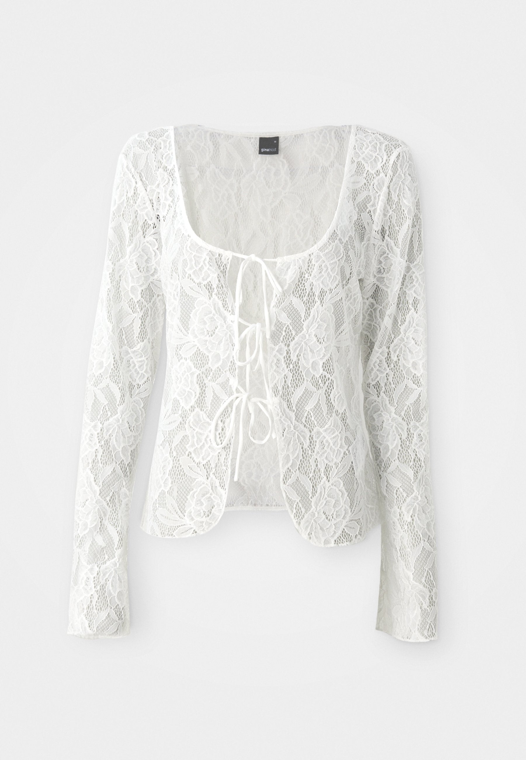Weißer Spitzen-Cardigan mit langen Ärmeln, Rundhalsausschnitt und Bindegürtel-Closure. Blumendesign mit transparenter Textur und geschwungenem Saum.
