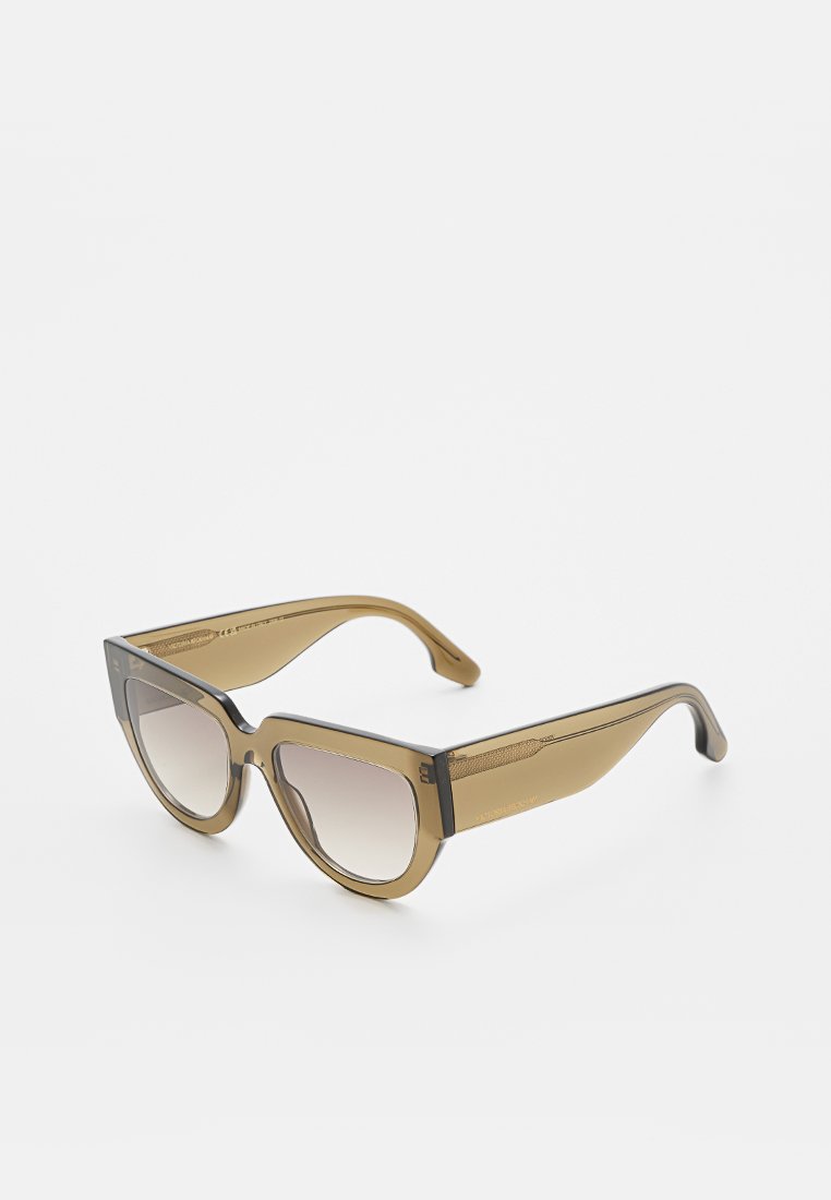 Braune durchsichtige Cat-Eye-Sonnenbrille mit verlaufsfarbenen Gläsern, auf einer weißen Oberfläche platziert, um den Vorder- und Seitenrahmen zu zeigen.