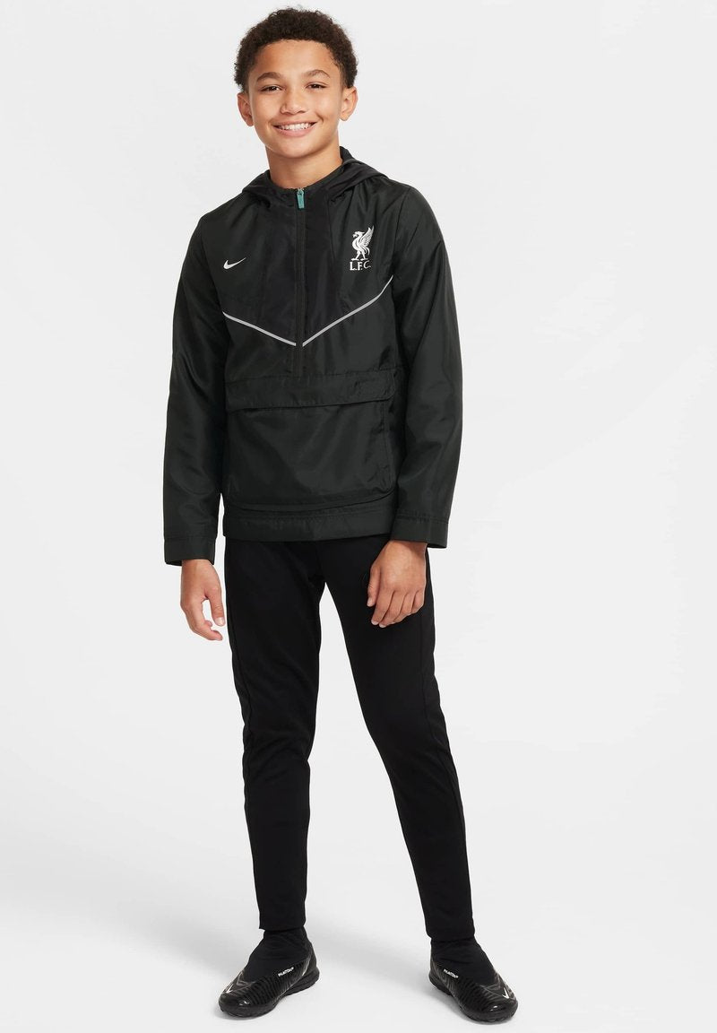 Schwarze Nike-Jacke mit Kapuze, die ein Liverpool FC-Logo und graue Akzente aufweist; getragen über schwarzen Hosen und schwarzen Schuhen.