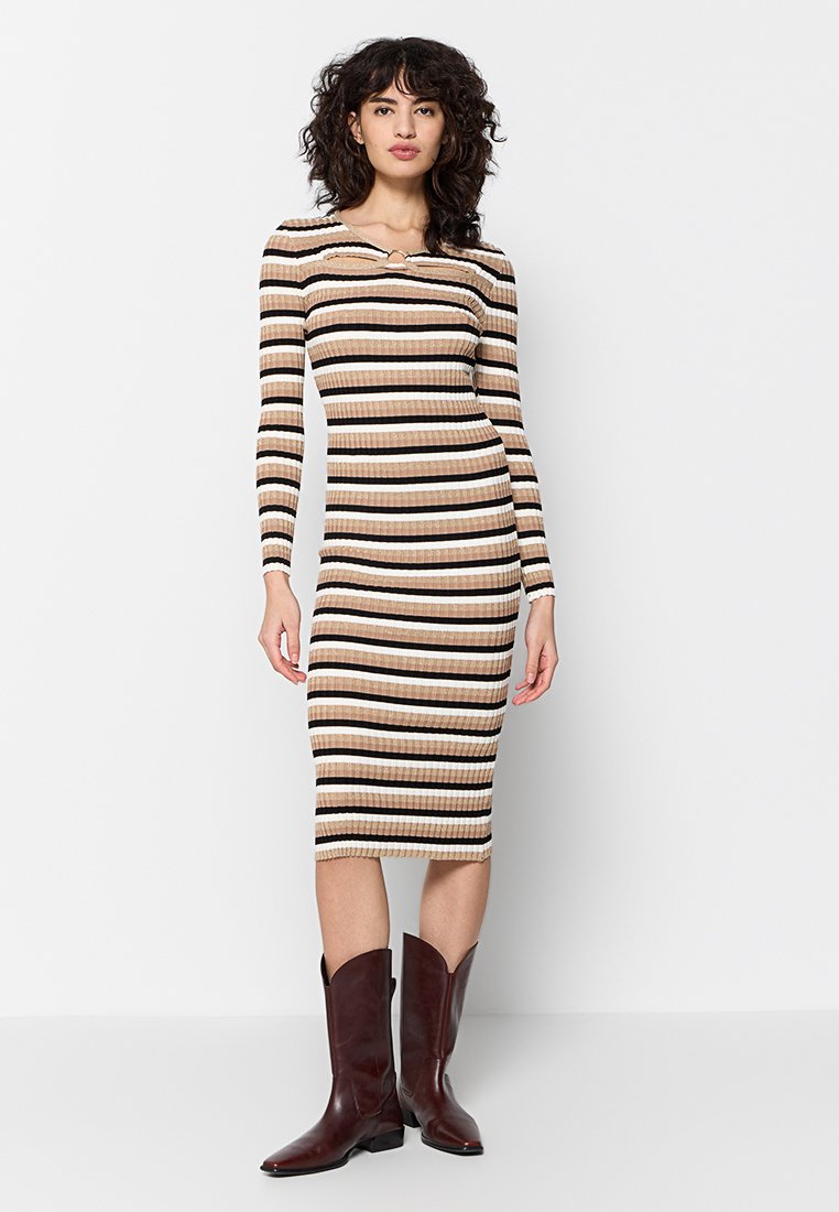 Rippkleid mit langen Ärmeln und Midi-Länge, das horizontale Streifen in Beige, Creme und Braun aufweist. Das Model trägt braune Cowboy-Stiefel mit spitzer Zehenform.