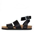 Schwarze Sandalen mit zwei breiten Riemen und einem schmaleren Knöchelriemen mit einer Metallschnalle. Korkfußbett und strukturierte Gummisohle. Marke: Bayton.