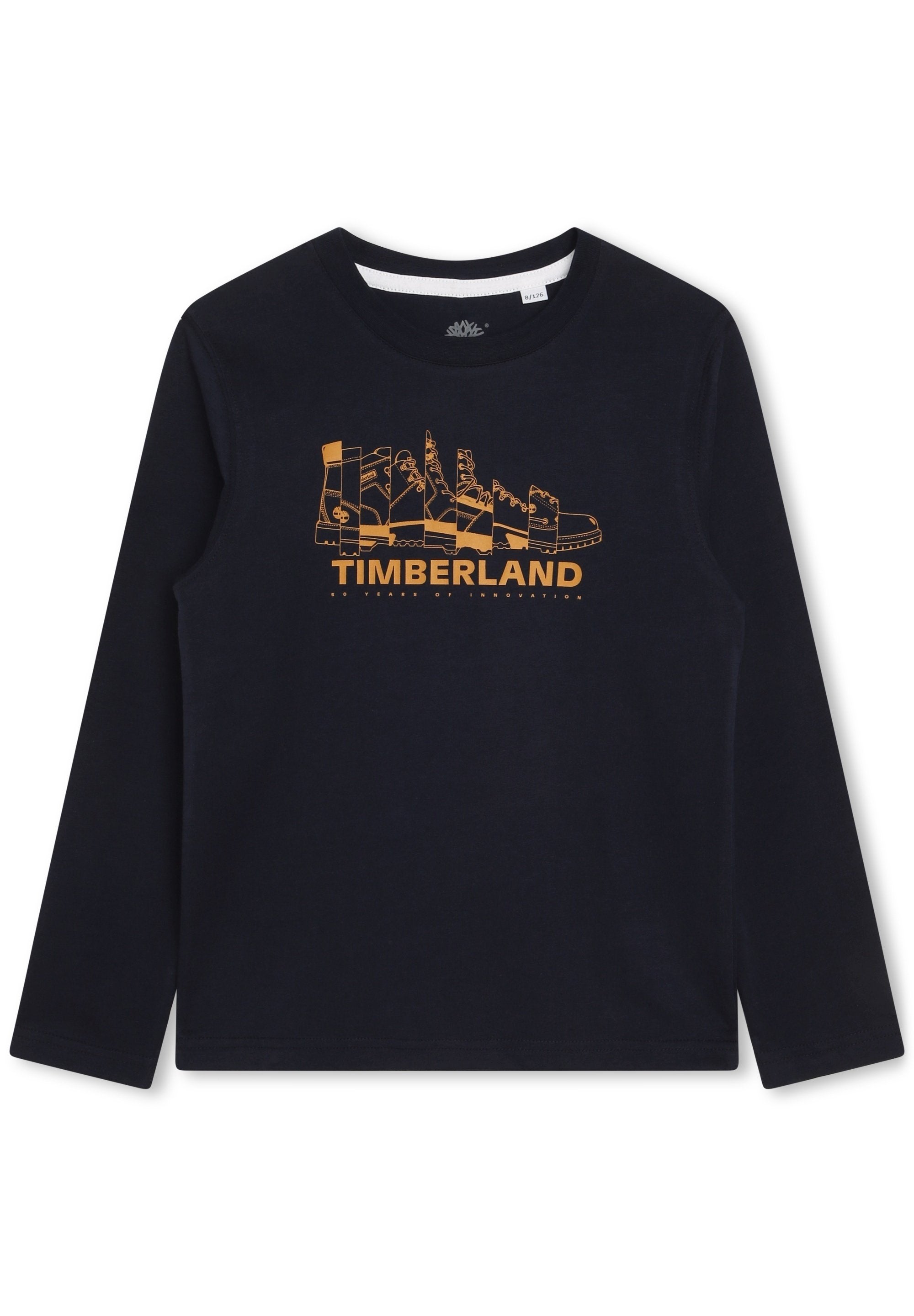 Langärmliges navyblaues Hemd mit einer orangefarbenen Grafik verschiedener Timberland-Stiefel und dem Text "TIMBERLAND 50 Jahre Innovation" darunter.