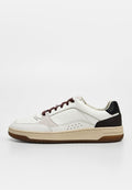 Weißer Ledersneaker mit schwarzem Fersenpatch, braunen Schnürsenkeln, beiger Sohle und perforiertem Seitendetail, von der Außenseite gesehen.