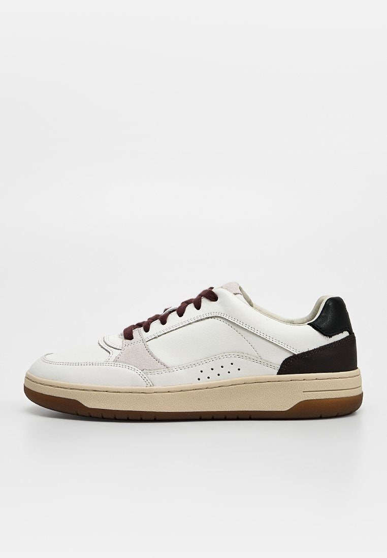 Weißer Ledersneaker mit schwarzem Fersenpatch, braunen Schnürsenkeln, beiger Sohle und perforiertem Seitendetail, von der Außenseite gesehen.
