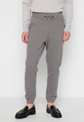 Graue Jogginghosen aus weichem Material, ausgestattet mit einem elastischen Bund mit Kordelzug, Bündchen an den Knöcheln und seitlichen Taschen.