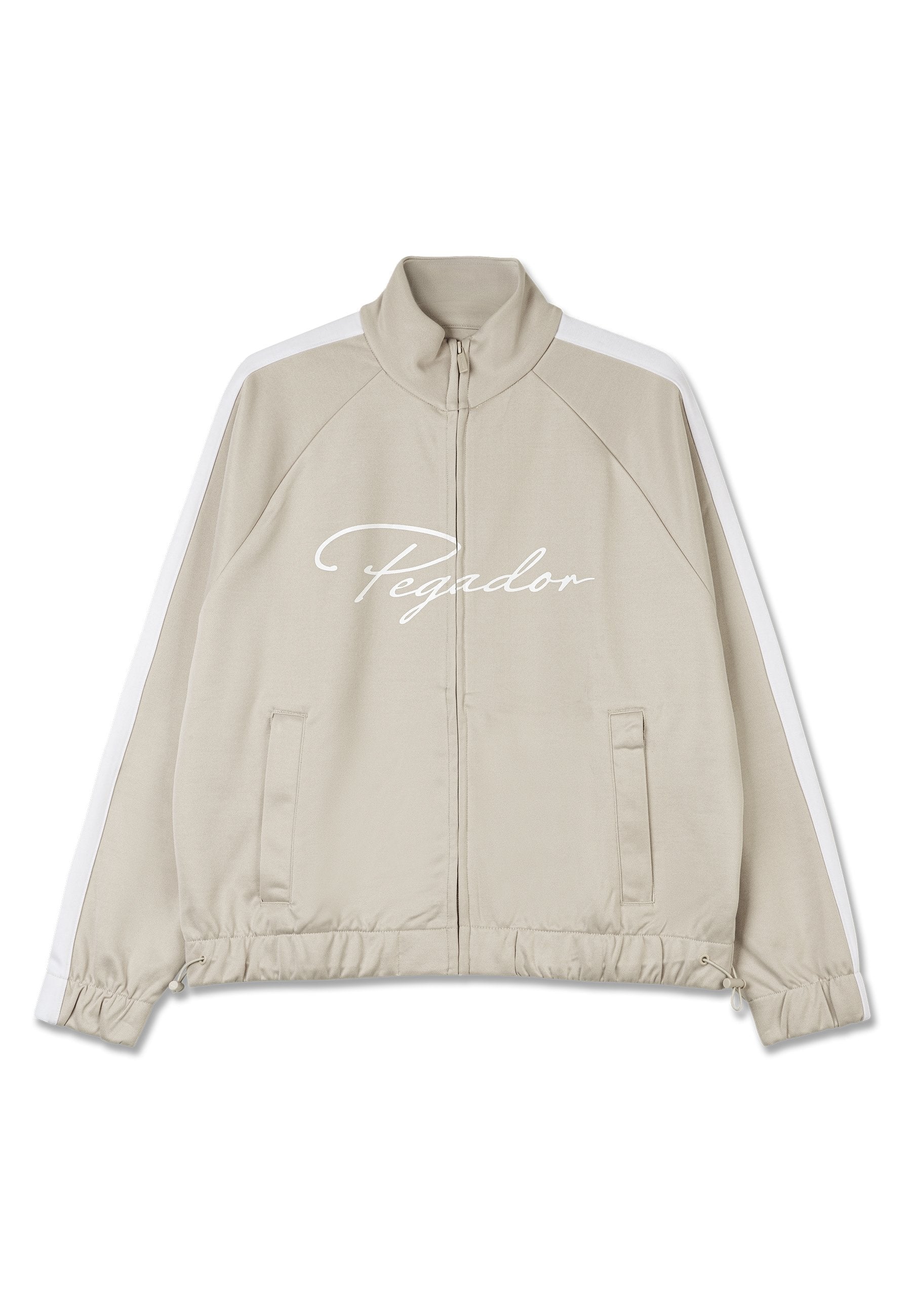 Beige Zip-Jacke mit weißen Akzenten, hochschließender Kragen, elastische Bündchen, Kordelzug am Saum und "Pegador"-Logo auf der Vorderseite.