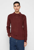 Bordeauxroter gestrickter Pullover mit langen Ärmeln, Polokragen, Drei-Knopf-Leiste und einem erhöhten Rautenmuster auf der Stoffoberfläche. Lässiger Schnitt.
