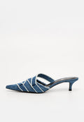Denim-Mules mit spitzer Zehenpartie, ausgestattet mit weißen Nähten und überkreuzten Riemen. Der schmale Absatz und die weiche Textur verleihen einen lässigen Look.