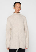 Hellbeiger Rollkragenpullover mit entspannter Passform, gerippten Bündchen und strukturierter Stoff. Abgesenkte Schultern und lockere Silhouette.