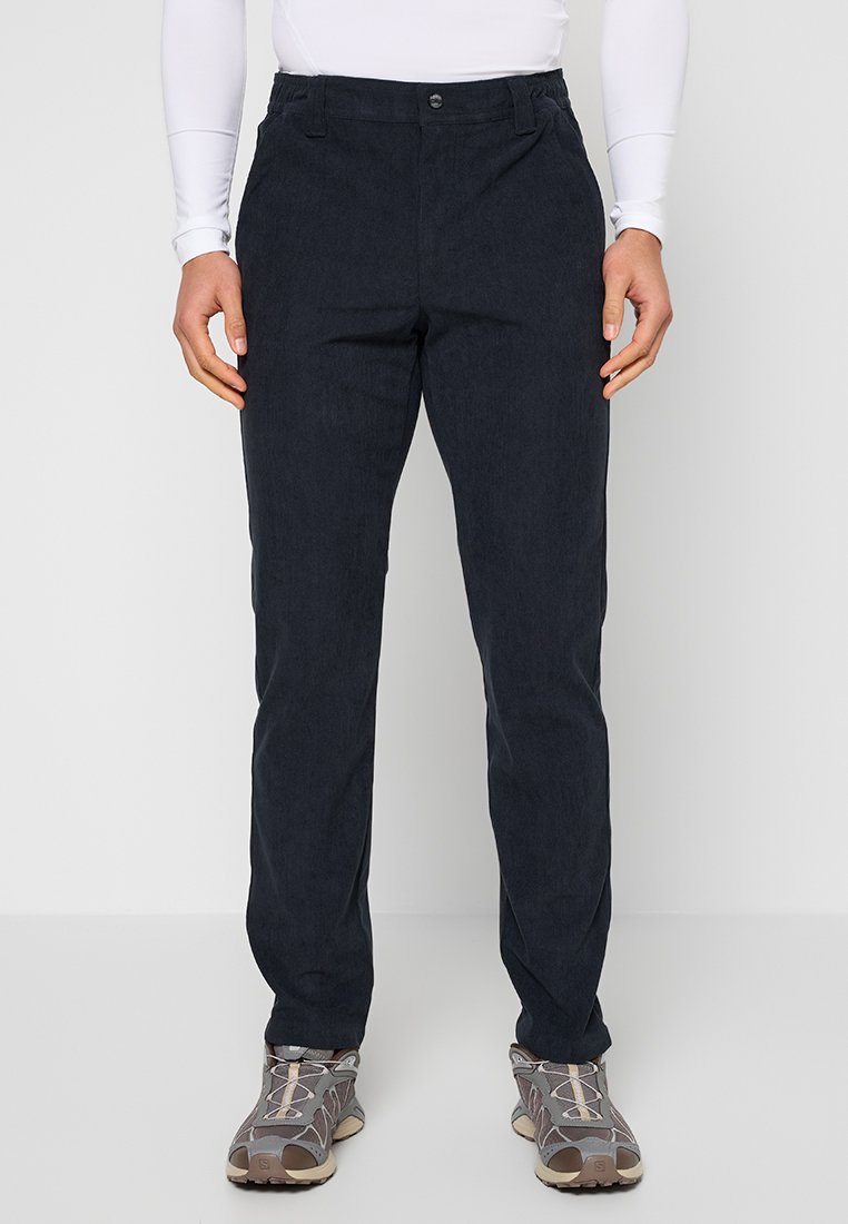 Marineblaue Hosen aus Baumwollmischgewebe mit geradem Schnitt, Gürtelschlaufen, vorderer Knopfverschluss und Seitentaschen, kombiniert mit grauen Schuhen.