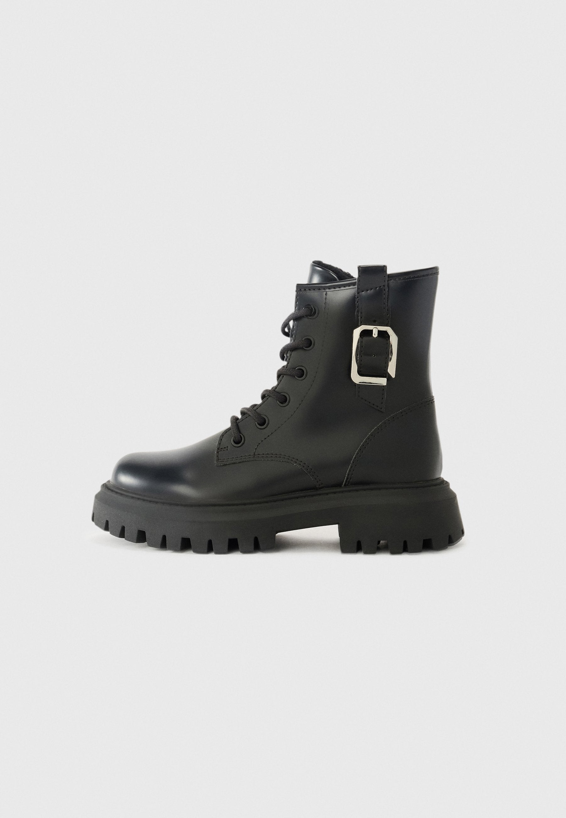 Schwarze Lederknöchelstiefel mit einer klobigen Sohle, Schnürverschluss an der Vorderseite und einem seitlichen Schnallenakzent. Glatte Textur und schlankes Design.