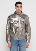 Metallisch silberne Denimjacke mit zwei Brusttaschen, einer durchgehenden Knopfleiste und einer strukturierten Oberfläche. Getragen mit einem blauen Hemd darunter.