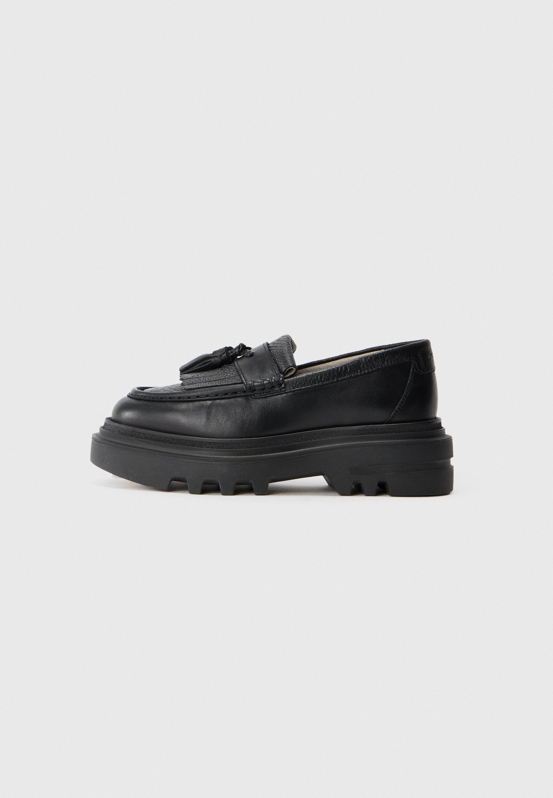 Schwarze Lederloafers mit einer robusten Gummisohle und gerippter Textur. Mit einer geflochtenen Akzentuierung auf der Vorderseite. Seitenansicht dargestellt.