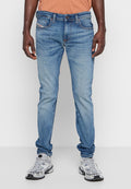 Helle blaue Denim-Jeans mit schlankem Schnitt, fünf Taschen und dezenten Verwaschungen. Mit orangem Nähen und Knopfverschluss.