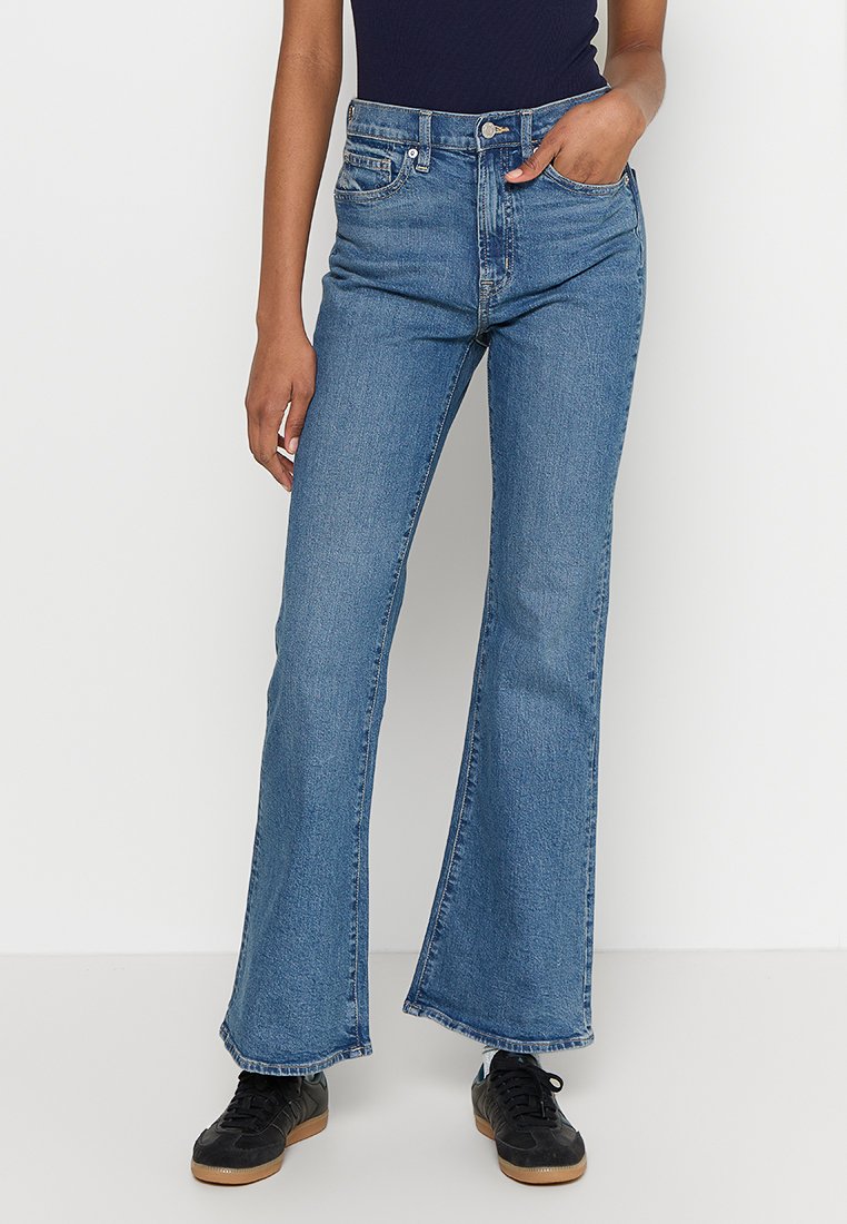 Hellblaue, ausgestellte Jeans mit hoher Taille, fünf Taschen und einem leicht ausgefransten Saum. Texturiertes Baumwollgewebe.