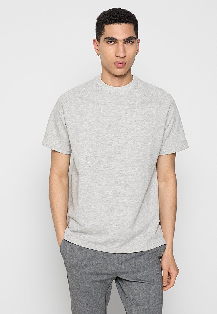 Graues Baumwoll-T-Shirt mit kurzen Ärmeln, Rundhalsausschnitt und Raglanärmeln, das eine glatte Textur und ein dezentes meliertes Muster aufweist.