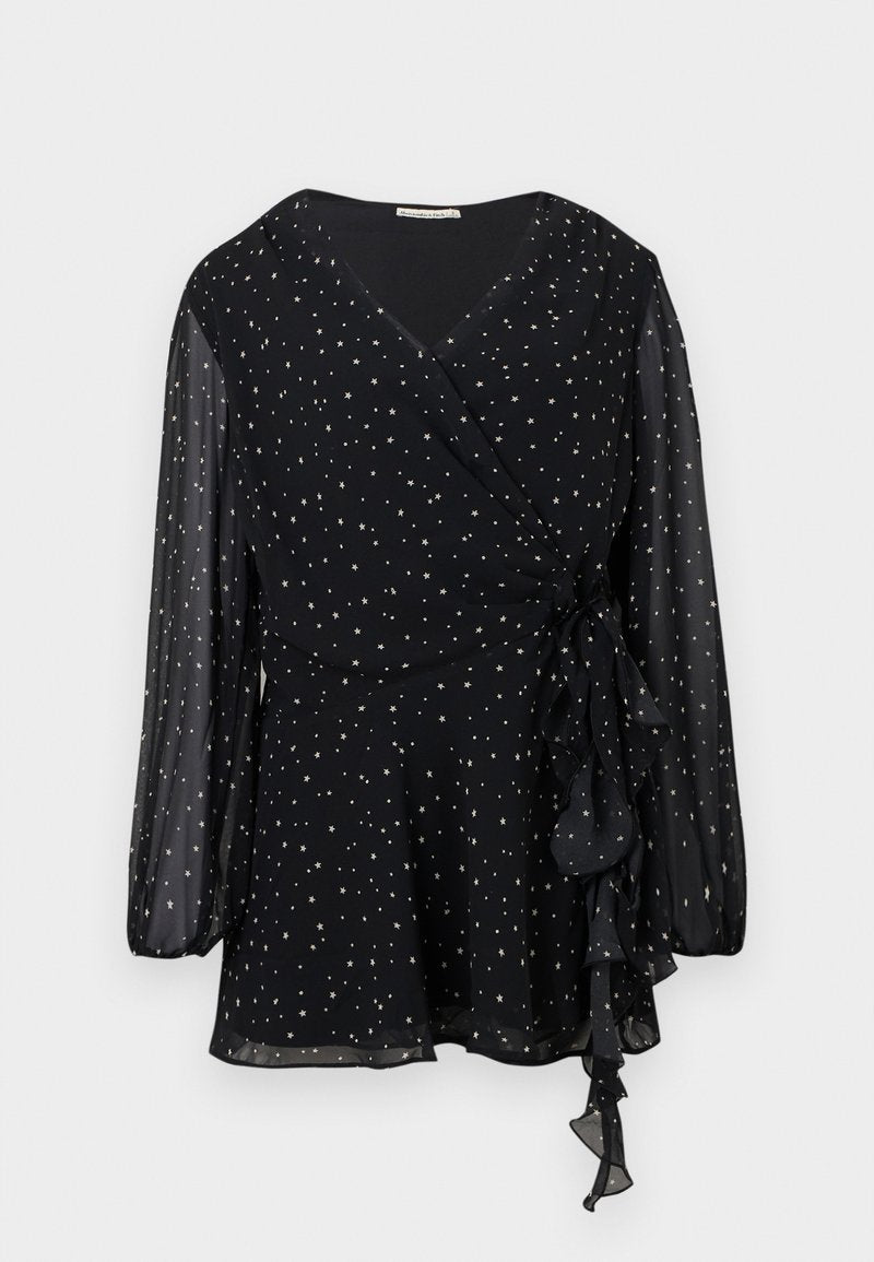 Schwarze, durchscheinende Bluse mit langen Ärmeln im Wickellook, mit silbernem Sternenmuster und gerafftem Bindedetail an der Seite.