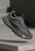 Graue Trailrunning-Schuhe mit einem strukturierten Obermaterial aus Stoff, verstärkter Zehenpartie und flexibler Gummisohle mit ausgeprägten Stollen für Traktion.