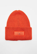 Helles oranges gestricktes Beanie mit umgeschlagenem Bund, der eine rechteckige "Tommy Jeans"-Logo-Patch und ein kleines Flaggenemblem auf der Vorderseite zeigt.