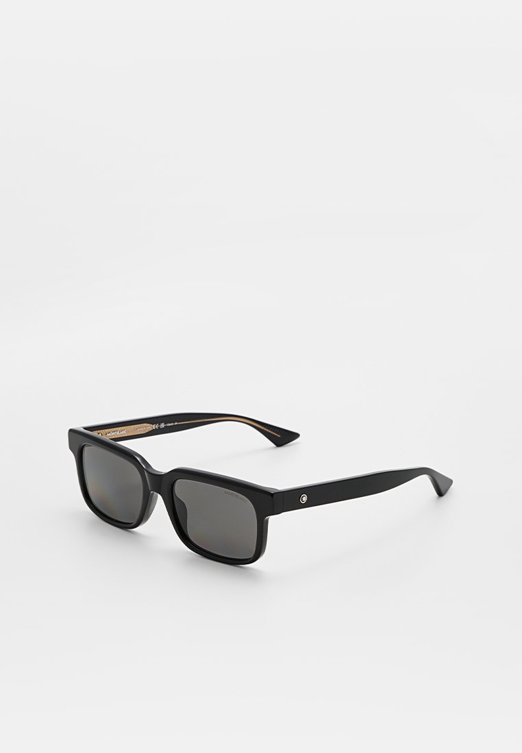 Schwarze rechteckige Sonnenbrille mit dunklen Gläsern und schlanken Bügeln, die schräg auf einer weißen Oberfläche liegt.