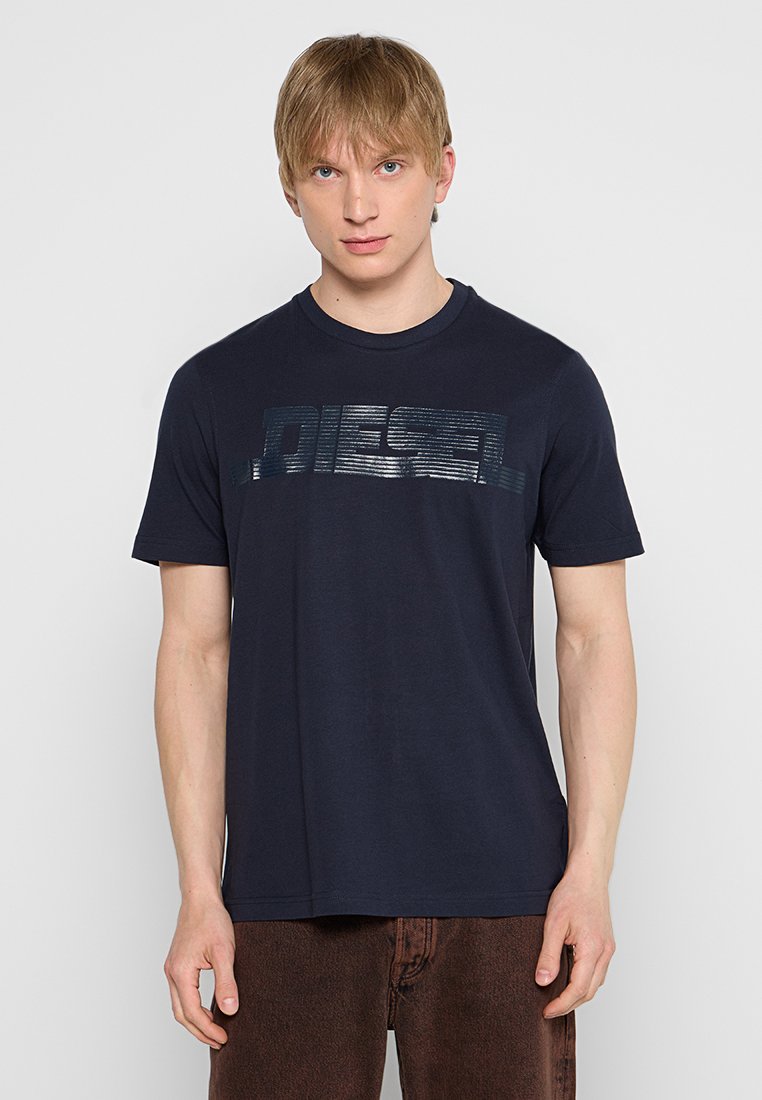 Dunkelblaue Baumwoll-T-Shirt mit einem glänzenden, horizontalen Textlogo "DIESEL" über der Brust. Kurze Ärmel und ein klassischer Rundhalsausschnitt.